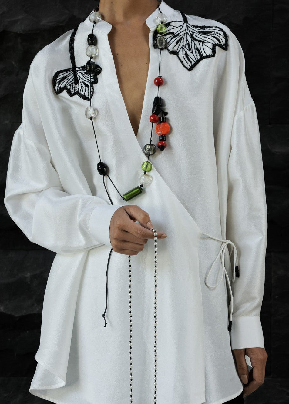 White shirt with black butterfly embroidery on a dark background