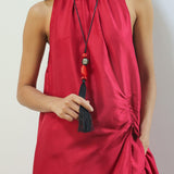 Red halter neck dress worn by a person against a plain background