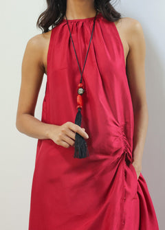 Red halter neck dress worn by a person against a plain background
